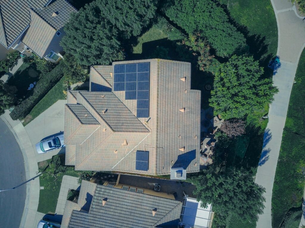 pexels-photo-9875680-9875680 Top-down aerial view of a house with solar panels, showcasing modern renewable energy solutions.