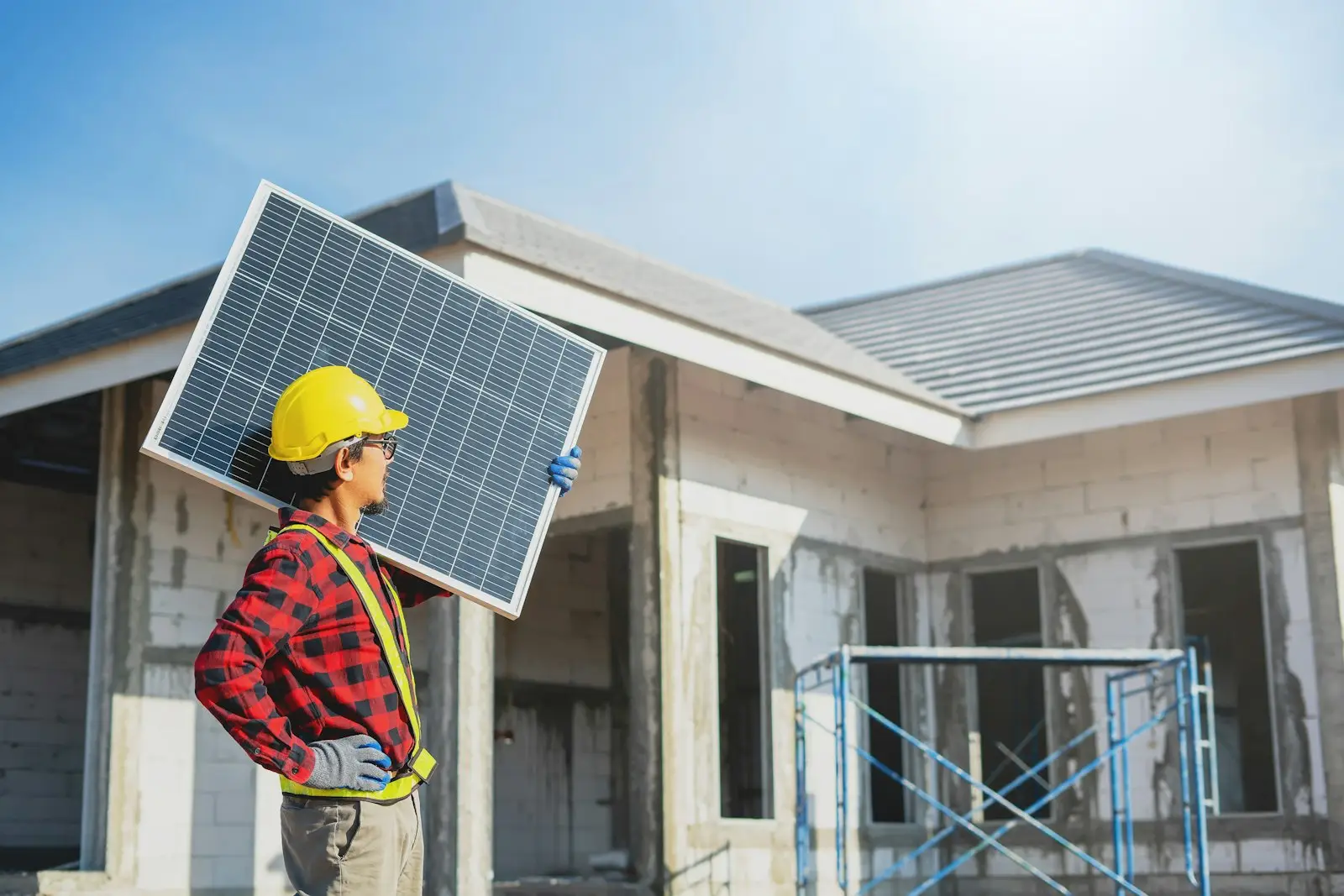 Installer carrying a solar panel to a house