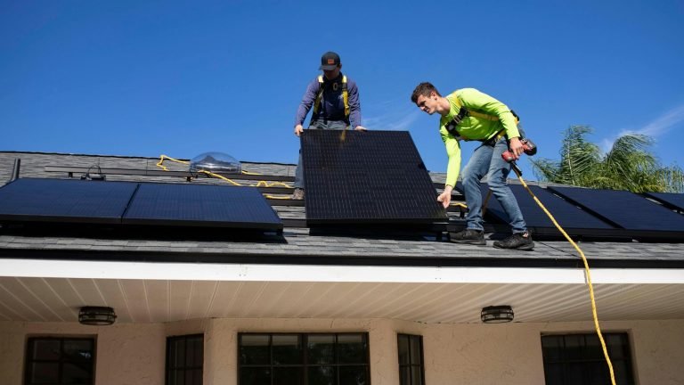 Installers mounting solar panels on a residential roof