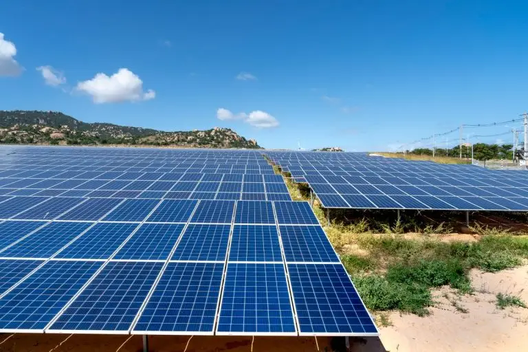 Solar panels in a field under blue sky - generator vs solar