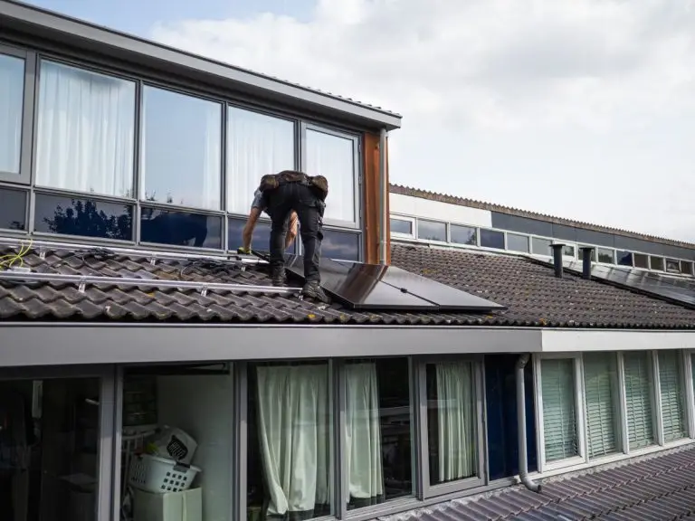 Technician installing solar panels on a rooftop - solar inverter warranty